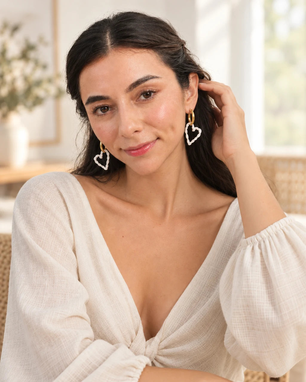 Aretes Corazón Trenzado A119, gesto con modelo