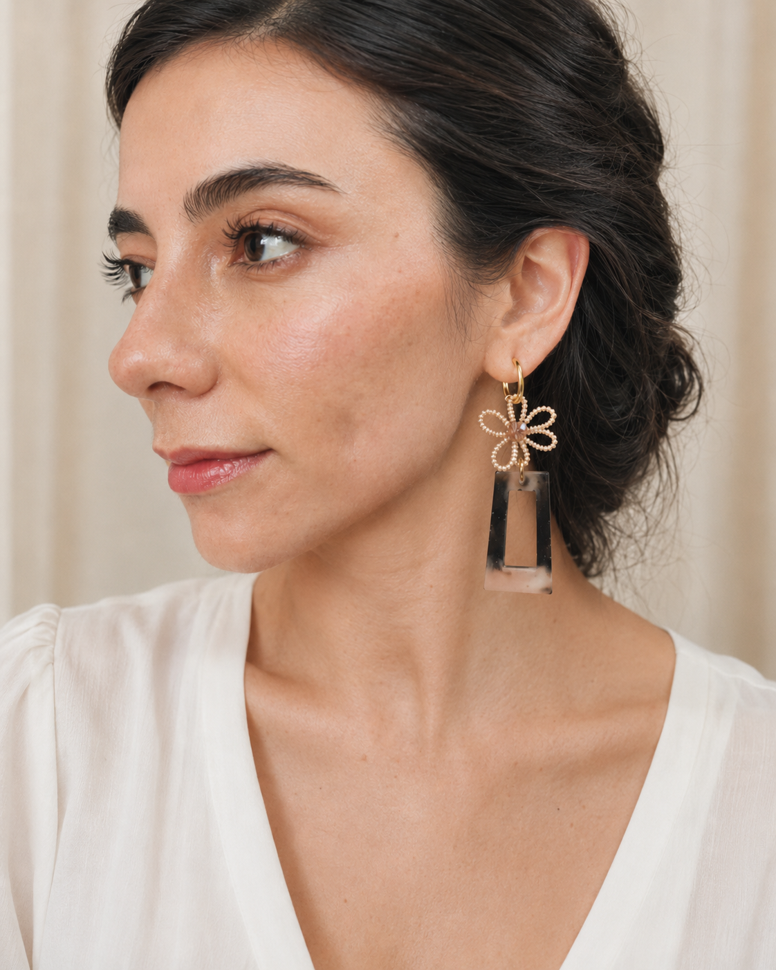 Aretes largos artesanales de mostacillas, murano y resina en modelo, vista tres cuartos