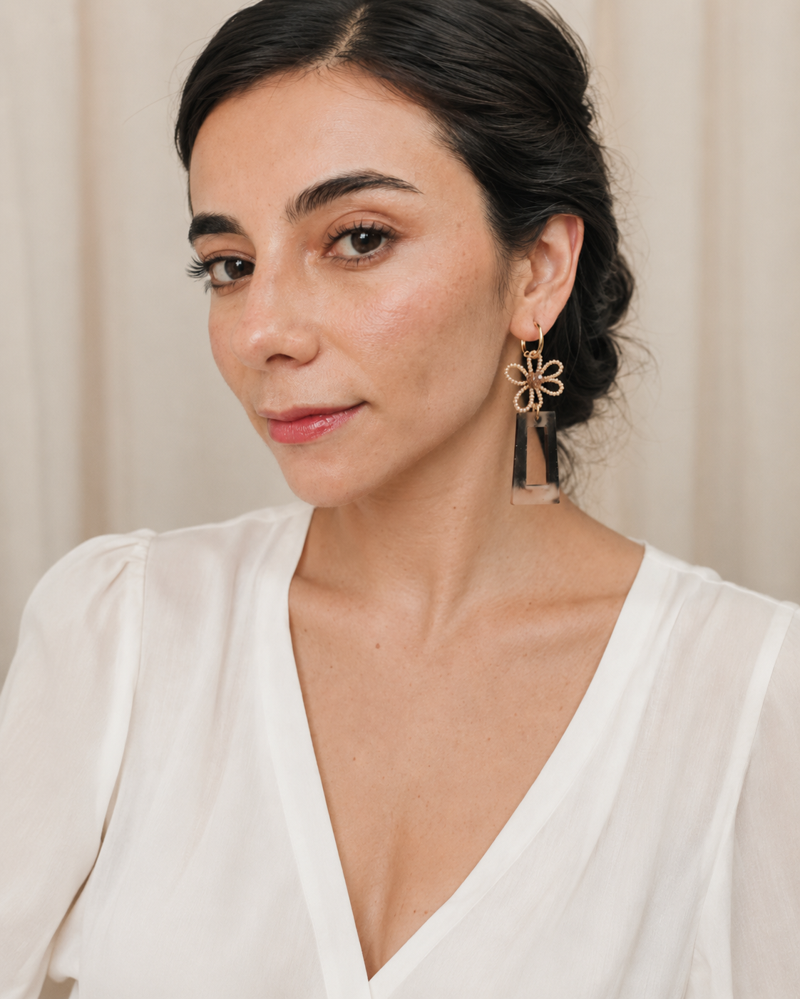 Aretes statement artesanales con argolla de acero, flor de mostacillas y resina en modelo