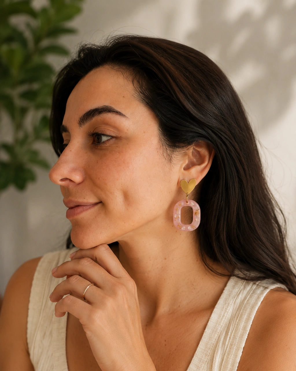 Tres cuartos y gesto de modelo usando aretes Dulce Corazón