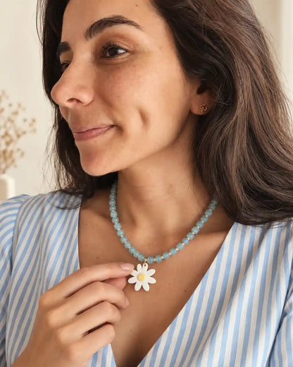 Brisa Margarita, collar aqua con flor blanca y centro amarillo, gesto en modelo