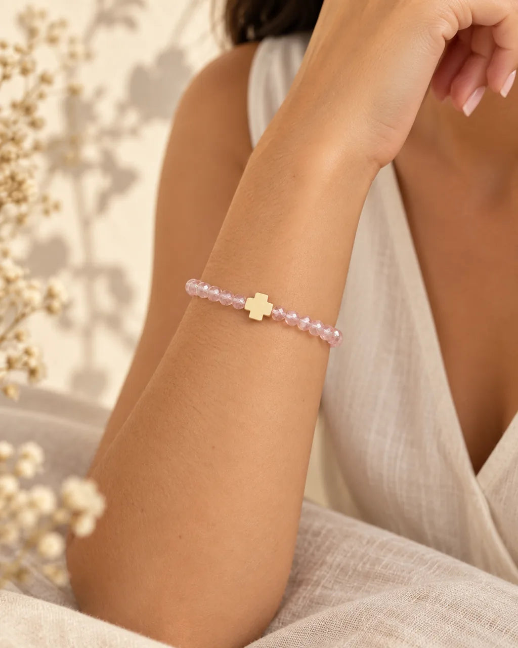 Luz Serena – pulsera rosada con cruz en muñeca, detalle