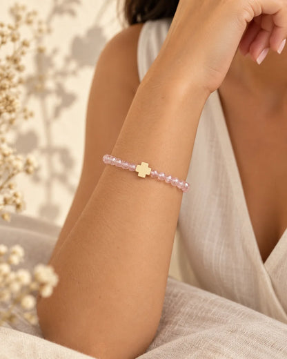 Luz Serena – pulsera rosada con cruz en muñeca, detalle