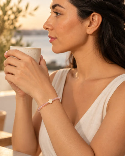 Luz Serena – pulsera rosada con cruz, escena cotidiana
