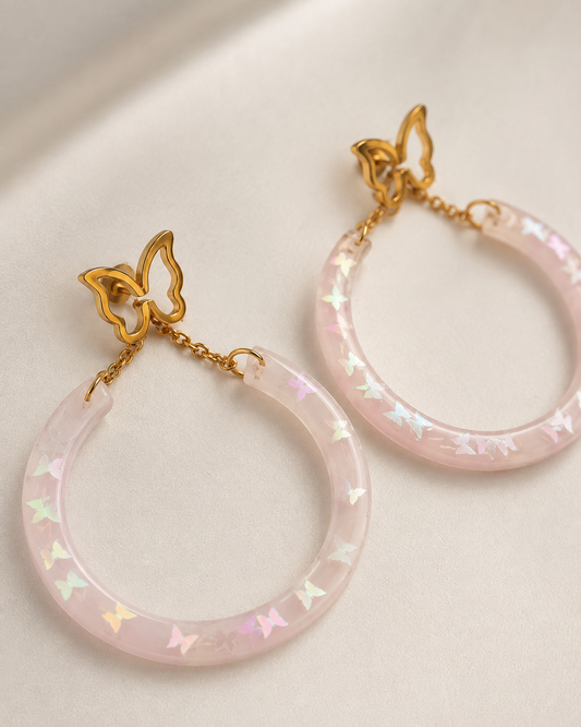 Aretes hechos a mano con mariposa dorada y aro rosado iridiscente