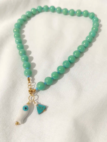 Verde Sereno – Collar artesanal de cuentas con dije pez y charm azul