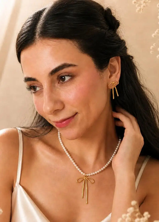 Brillo Romántico – Set dorado con perlas y lazo en acero