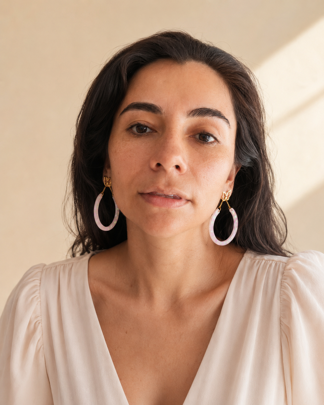 Modelo usando aretes de mariposa y aro iridiscente