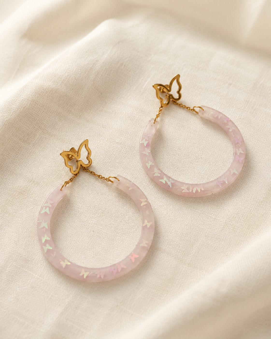 Aretes de mariposa dorada con aros rosados iridiscentes